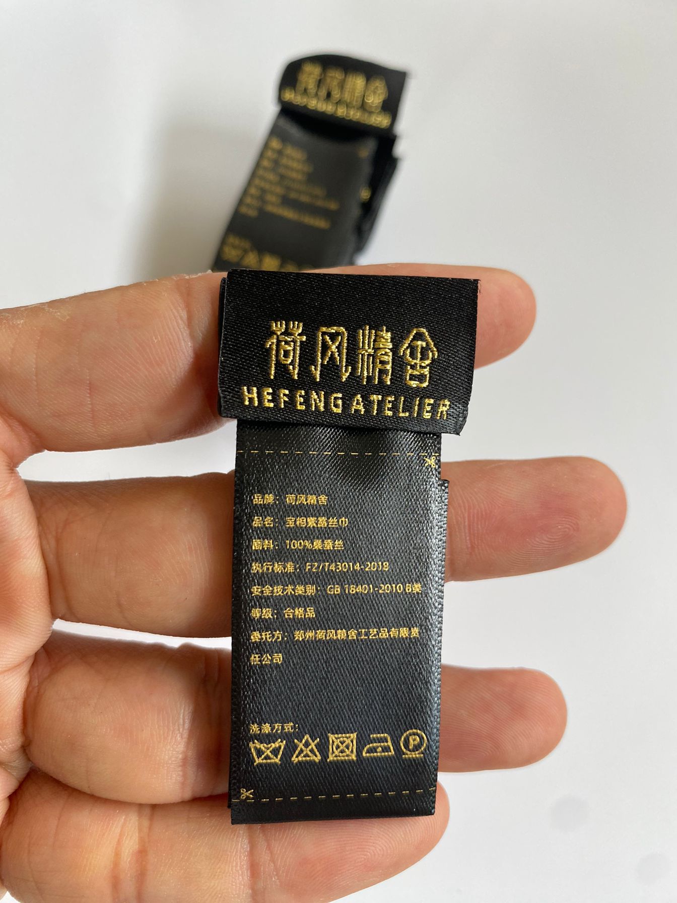 内折黑色丝带洗水唛，丝印金色文字细节放大实拍